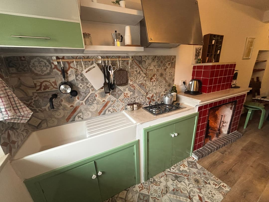 Cucina con mobili verdi e piano cottura