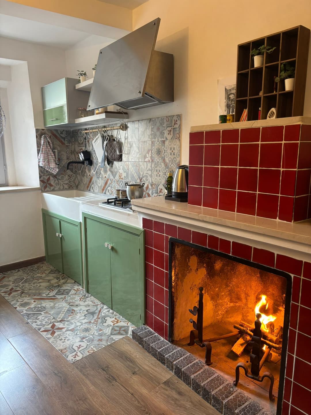 Cucina rustica con camino acceso e piastrelle artistiche